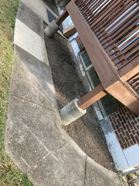 The bed dug out to bare dirt, the concrete piers and the base of the brick finally visible