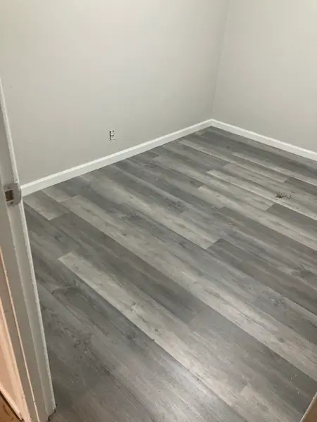 A room with the new plank floor finished and the base run, swept and ready to hand back.